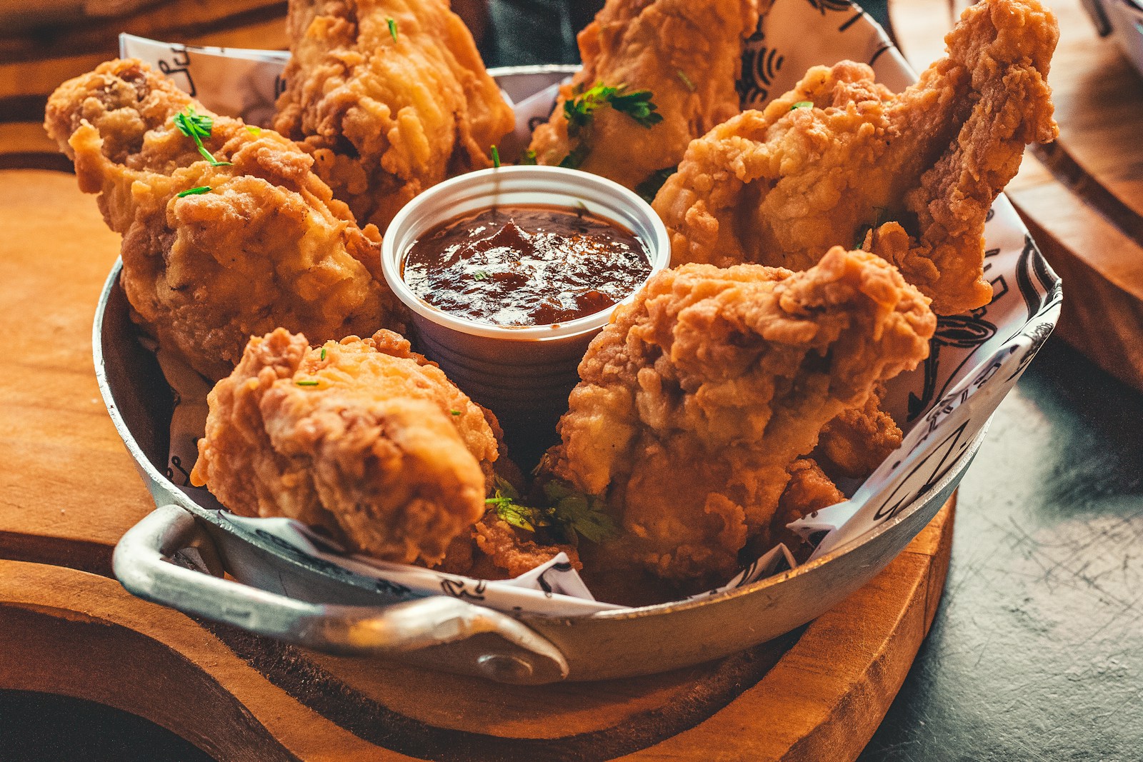 Crispy battered pieces in a metal pan with dipping sauce