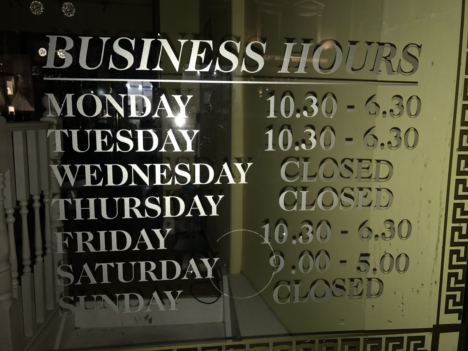 Opening hours painted on the shop window at 92 Haverstock Hill