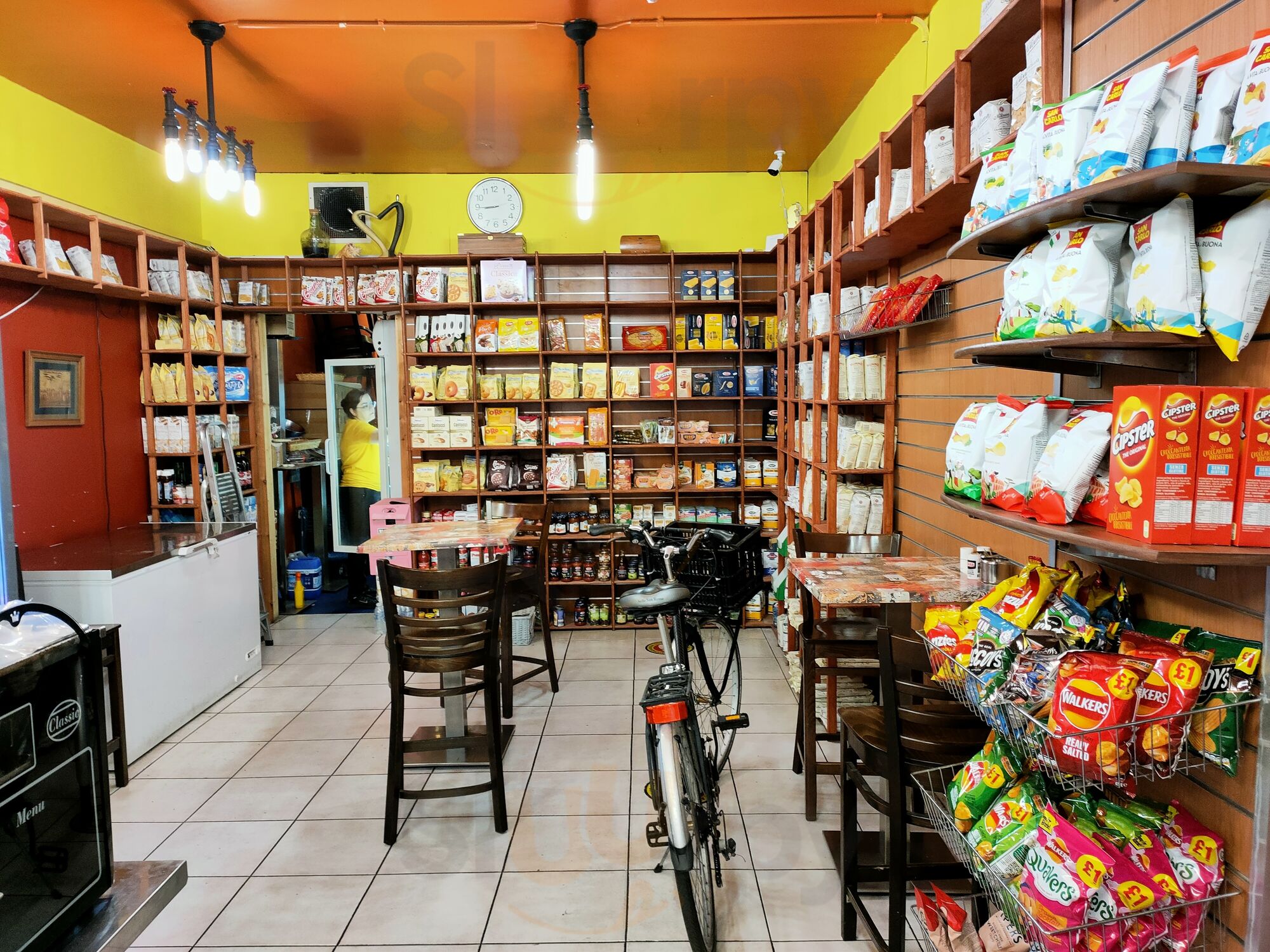 Grocery shelves and limited seating inside La Cigale