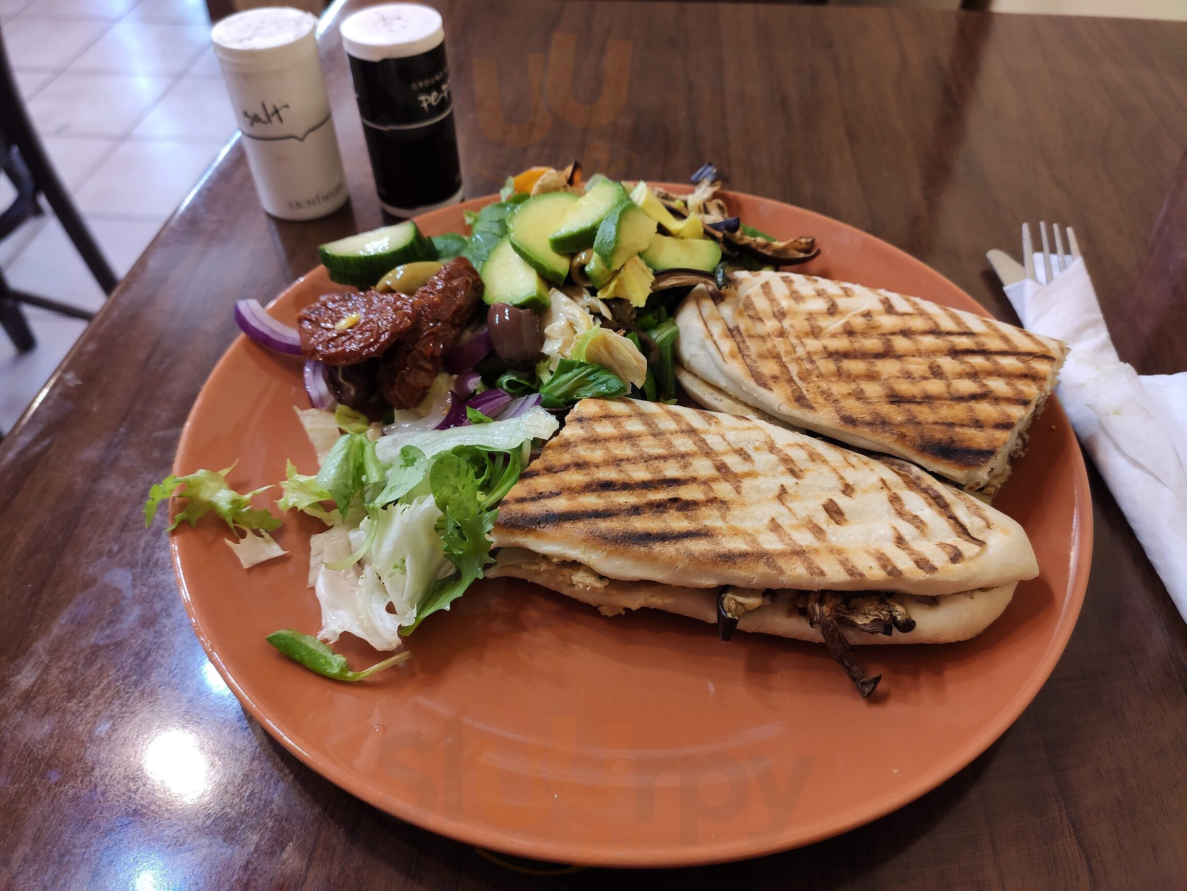 Grilled panini with avocado salad on a plate at La Cigale