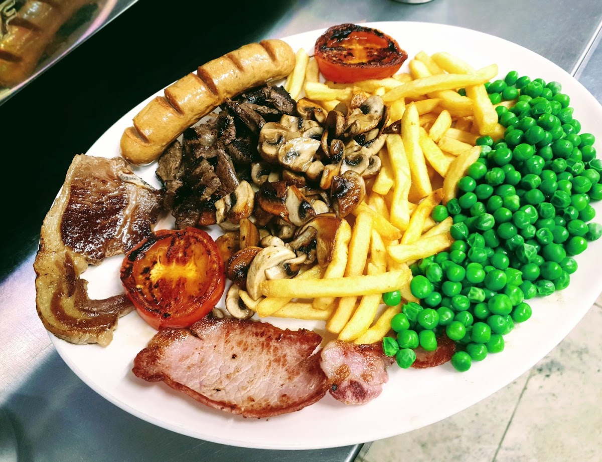 Mixed grill plate with chips, peas and sausage